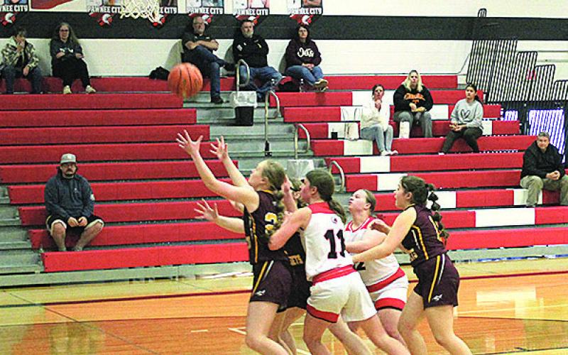 Members of the Junior Varsity Pawnee City Indians and Sterling Jets teams reach for the ball as it falls from the hoop