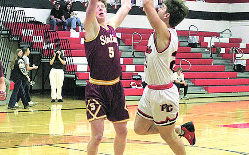 Pawnee City Senior Tyler Tegtmeier shoots for a score as Sterling Junior Owen Uher attempts to block