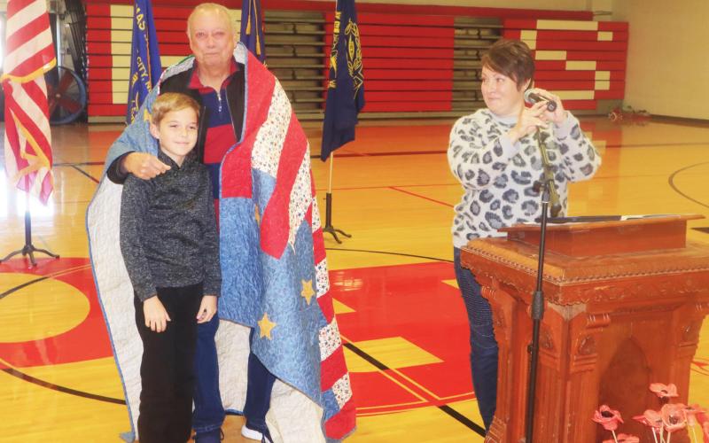 Ray Kappel/Republican Veteran Larry Sinagoga with his grandson JJ Maynard and his mom, Beka at the Pawnee City Schools Veterans Day program. JJ made a Quilt of Valor for his grandpa.