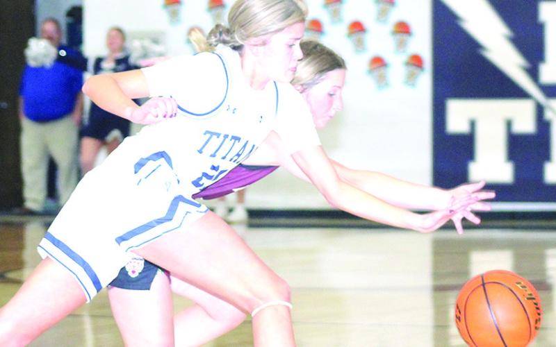 HTRS’ Avery Dierberger (#21 left) goes for a steal against Lewiston’s Justice Currie in the early part of the game on Tuesday night. HTRS won the game, 52-10. Paula Jasa/Republican