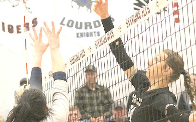 HTRS’ Hannah Koziol (#7, left) goes up strong at the net against an E-M-F player. Paula Jasa/Republican
