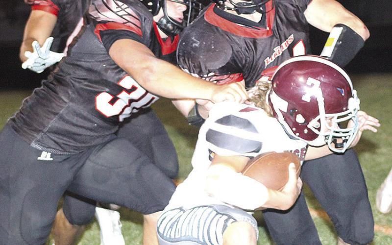 LHS’ Cashton Steinacher (#7, right) gets brought down short of the goal line by P.C.’s Dylan Layne (#30, left) and Jett Farwell (right) on a huge 4th down play. Paula Jasa/Republican