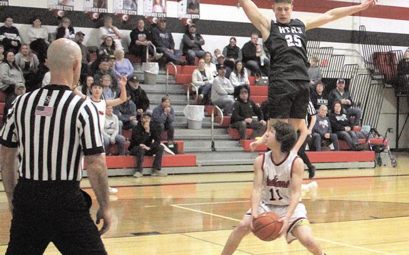 Pawnee City Indian Braydon Frakes prepares to make a shot as HTRS Titan Emmett Glathar jumps to block it