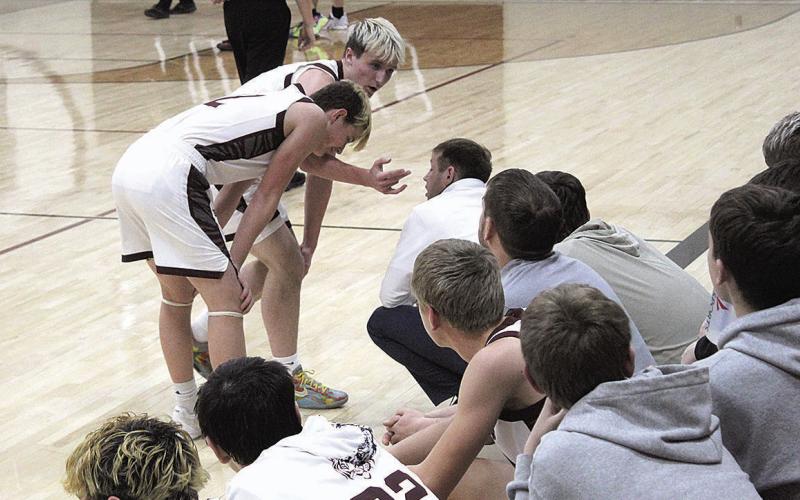 Lewiston Tigers Grady Weyers and Cashton Steinacher consult with Coach Kyle Asche courtside