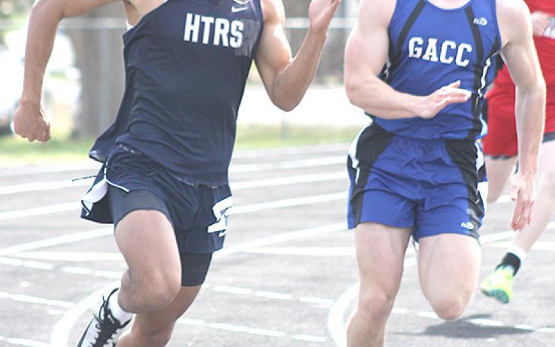 Paula Jasa/Republican HTRS’ JJ McQueen (left) rounds the corner in the 200 M. Dash. McQueen placed 5th in the finals.