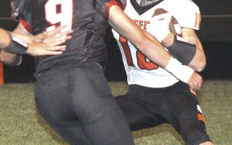 Pawnee City’s Anthony Kling (pictured above, left) gets teammate Jett Farwell (#14, right) to block out in front for him during a run against Diller/Odell on Friday night. Pictured right is P.C.’s Jesse McLaughlin (#9) getting after a Griffin ball-carrier in the backfield. All three seniors played their last game at Pawnee City in their 75-7 victory. photos by Paula Jasa/Republican
