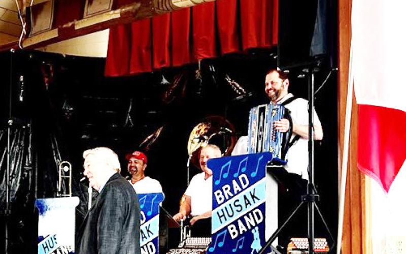 Joe Stehlik, the band’s sponsor, poses with them upon request
