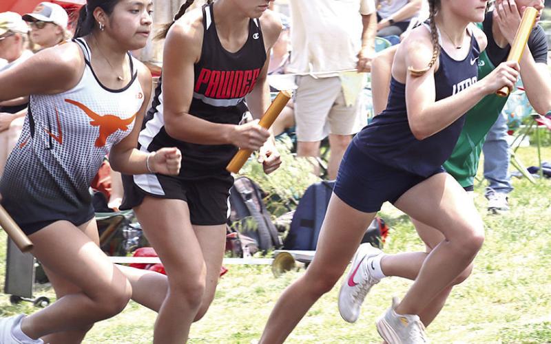 HTRS’ Grayson Sherman (right) and Pawnee City’s Emalyse Gottula (left, center) are determined in their first legs of the girls’ 3200 M. Relay.