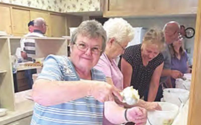 Dipping up pineapple ice cream, Judy Bausch, who has attended Salem for 45 years. “I have made a lot ice cream!” she says.