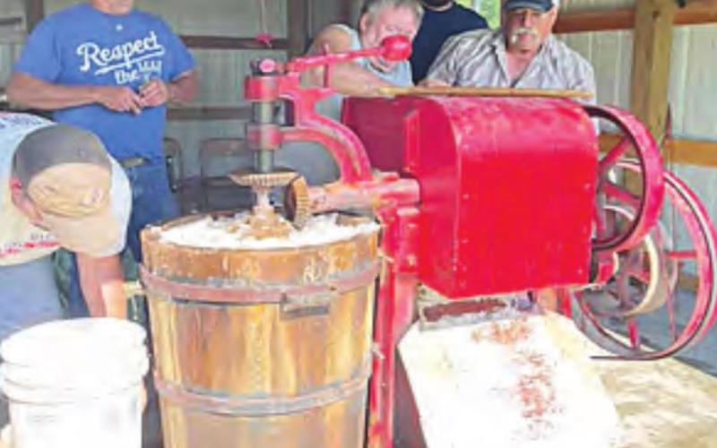 Making ice cream using the 10-gallon freezer. The red is the machine attached to and the waist-high bucket of ice that holds the freezing ice cream. Photo by Katy Kreifel.