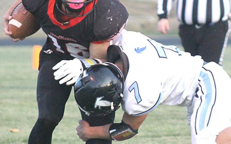 P.C.’s Anthony Kling (#16, left) attempts to shed a Falcon tackler in Friday night’s quarterfinal game. Paula Jasa/Republican