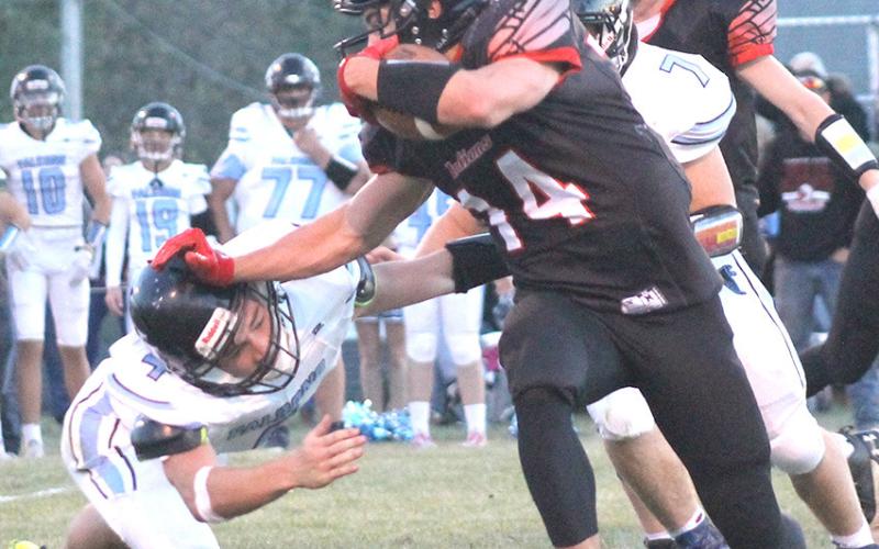 P.C.’s Jett Farwell (#14, right) stiff-arms a would-be Falcon tackler in Pawnee City’s Friday night quarterfinal game. Pawnee City lost to Wilcox-Hildreth, 14-33. Paula Jasa/Republican