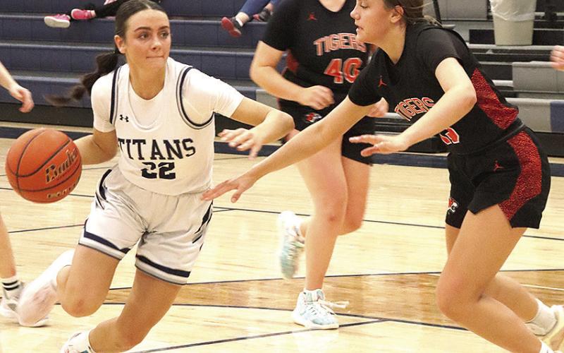 HTRS’ Lillian Bowen (#22, left) drives past several Falls City defenders in Thursday night’s game. Bowen led the Lady Titans with 17 points against Falls City. Paula Jasa/Republican
