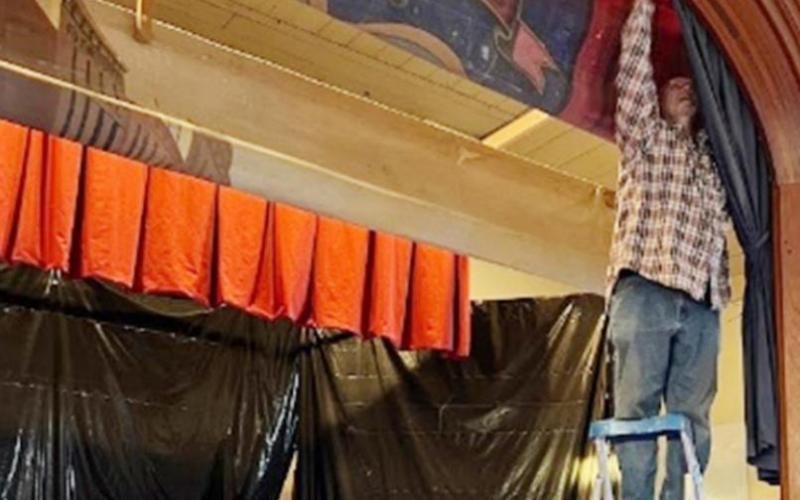 Terry Brewer working on the proscenium curtain