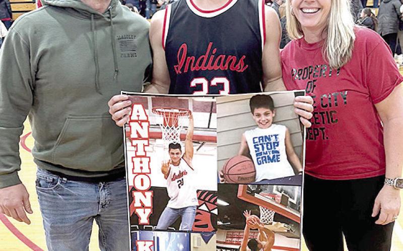 P.C.’s Anthony Kling (center) pictured with Shane and Jamie Maloley, proudly displays his poster of achieving 1,000 career points for the Pawnee City Indians after their game against Johnson-Brock last week. Photo provided