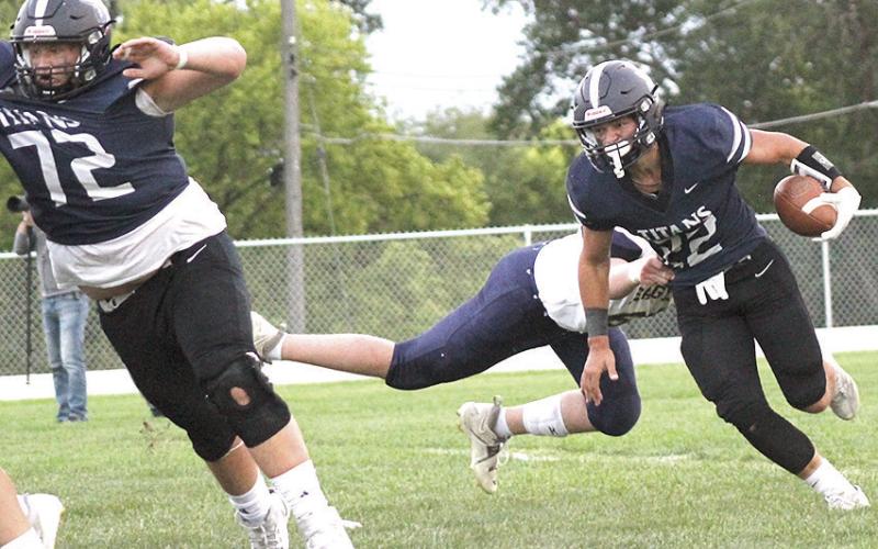 HTRS’ Hunter Bohling (#22, right) eludes a tackler in the backfield as teammate Jake Davis (#72, left) blocks out in front. Bohling rushed 25 times for 275 total yards and accounted for six of the Titans’ seven touchdowns in the 52-38 win over OCA. Paula Jasa/Republican