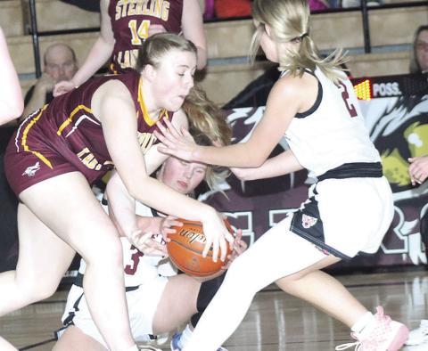 LHS’ Ayden Hunzeker (#3, center) fights for a loose ball as teammate Justice Currie (#2, right) looks to help out against Sterling.
