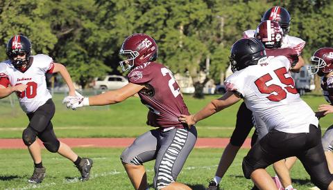 Lewiston’s Brock Janssen (#25) just gets by Pawnee City’s Justin Baehr (#55) on his way to a touchdown in the first half. photo by Paula Jasa, former sports editor