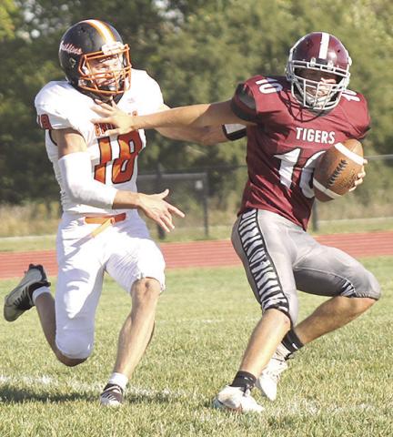 LHS’ Everett Bohling (#10, right) eludes a Griffin tackler and rolls back to the right side of the field to complete a touchdown pass right before the halftime break. Paula Jasa/Republican