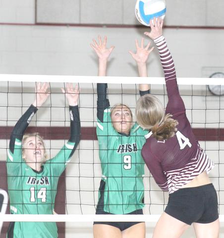LHS’ Emma deKoning (#4, right) skies for a tip over two FCSH blockers. Paula Jasa/Republican