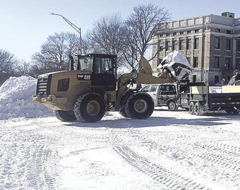 Above: Pawnee City workers cleared snow off the streets on Monday while Below: Ron Puhalla cleared the three foot snow dift in front of the newspaper office just in time for Betty Davis to come to work.