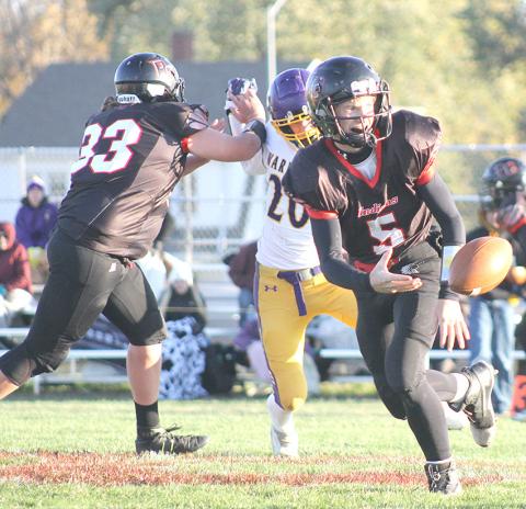 P.C.’s Justin Pierce (#5, right) flips the ball back to Anthony Kling on a long run as teammate Hayden Binder (#33, left) blocks for them. Paula Jasa/Republican