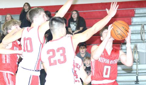 P.C.’s Drew Menninga (#20) and Anthony Kling (#23, left) prevent a Weeping Water player from driving the baseline in Tuesday night’s game before the Holiday break. Paula Jasa/Republican