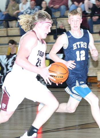LHS’ Tristen Ray (#24, left) takes off down the floor while HTRS’ Brogan Dunlap (#12, right) defends. HTRS defeated LHS in a close 52-45 game last Tuesday night. Paula Jasa/Republican