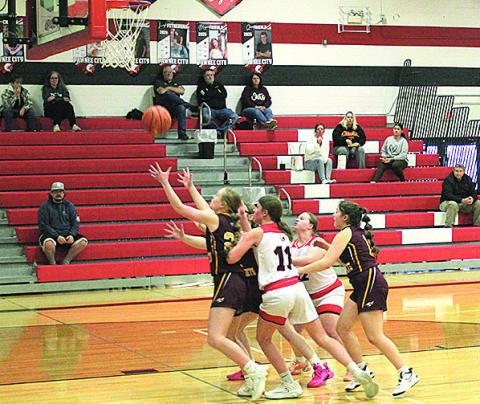 Members of the Junior Varsity Pawnee City Indians and Sterling Jets teams reach for the ball as it falls from the hoop