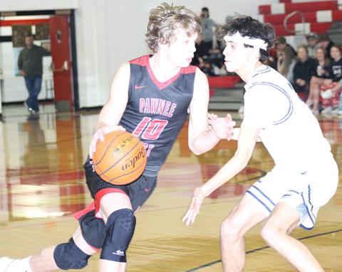 P.C.’s Kyle Gyhra (#10, left) drives against HTRS’ Nic Knudson (right) in Pioneer consolation action on Friday. Both players helped lead their teams in scoring. Paula Jasa/Republican