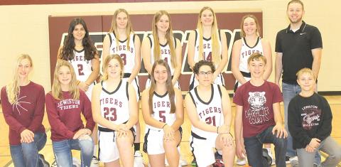 Members of the 2021-22 Lewiston Girls’ Basketball Team are front, from left: Maddie Janssen, s.m., Justice Currie, s.m., DeLanye Currie, Leah Christen, Delia Quintana, Payton Heideman, s.m., Evan Christen, s.m. Back row: Nayla Alos, Katelyn Sanders, Emma deKoning, Meagan Sanders, Carleigh Weyers, Head Coach Kyle Asche. Not pictured: Asst. Coach Alex Callan.
