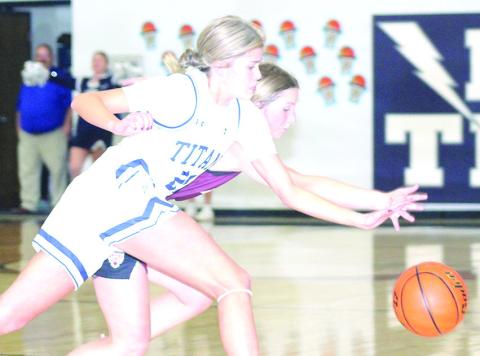 HTRS’ Avery Dierberger (#21 left) goes for a steal against Lewiston’s Justice Currie in the early part of the game on Tuesday night. HTRS won the game, 52-10. Paula Jasa/Republican