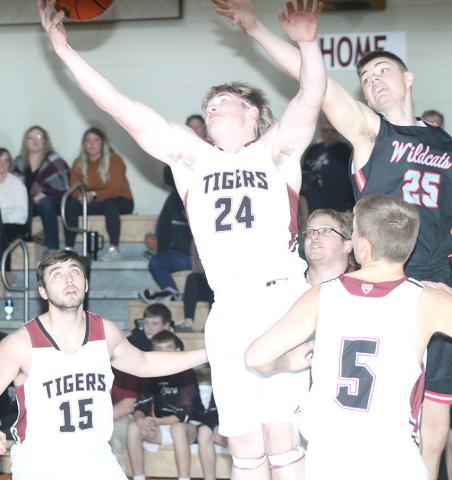 LHS’ Tristen Ray (#24, center) goes up for a rebound against Cedar Bluffs on Friday night while teammates Brady Bledsaw (#15, left); Everett Bohling (#5, right) look on. The Tigers won their third straight game of the week against Cedar Bluffs, 63-15. Paula Jasa/Republican