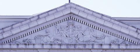 The pediment above the colossal Corinthian columns of the north portico. “Dentils” (small repeating blocks for ornamentation) run above and below it, “Triglyphs” (the four small blocks with grooves) anchor the triangular gable, and within the triangle is a terra cotta sculpture with interesting figures.