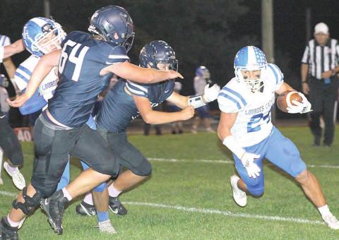 HTRS’ Andrew Stalder (#64, left) and Hunter Bohling (center, left) chase down a Lourdes Central Catholic ball-carrier in Thursday night’s final season game. Paula Jasa/Republican