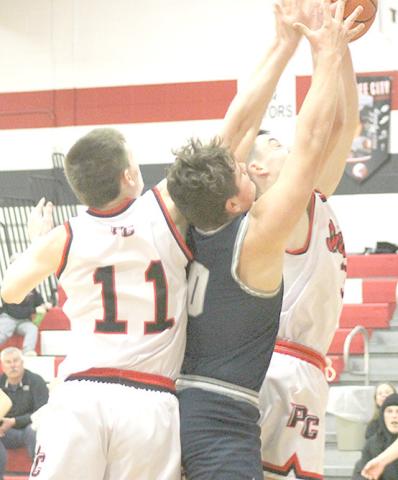 P.C.’s Brysen Horst (#11, left), HTRS’ Hunter Bohling (#0, center) and P.C.’s Jett Farwell (right) battle under the boards for a rebound at the Pioneer Tourney. Paula Jasa/Republican