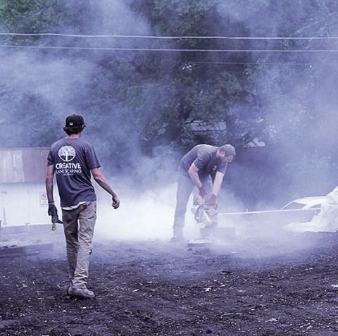 Garett Crist (right) and Thomas Heinz (left) of Creative Landscaping construct a retaining wall for Tranquility Park Photo by Reagan Connelly