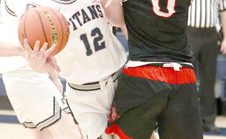 HTRS’ Brogan Dunlap (#12, center) drives the paint against Wymore Southern in the Titans’ home game on Saturday, December 17th. The Titans lost to the Raiders by a 39-71 score. (Individual statistics were not available at the time of printing.) photo courtesy of Lorrie Novak