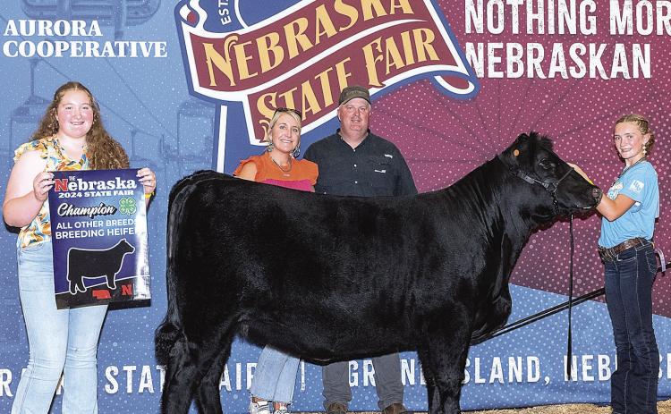 Sisters Adelyn (L) and Aubrey (R) with their parents Whitney and Andrew Sisco posed with their Champion Breeding Heifer