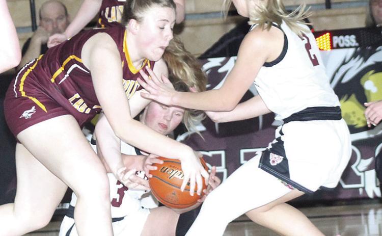 LHS’ Ayden Hunzeker (#3, center) fights for a loose ball as teammate Justice Currie (#2, right) looks to help out against Sterling.