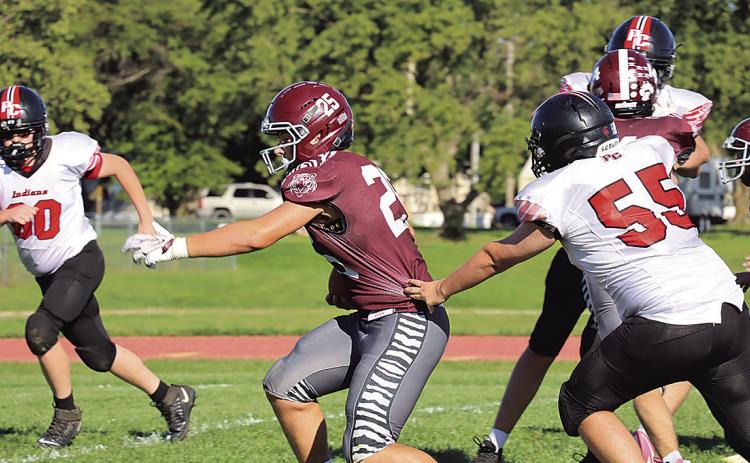 Lewiston’s Brock Janssen (#25) just gets by Pawnee City’s Justin Baehr (#55) on his way to a touchdown in the first half. photo by Paula Jasa, former sports editor