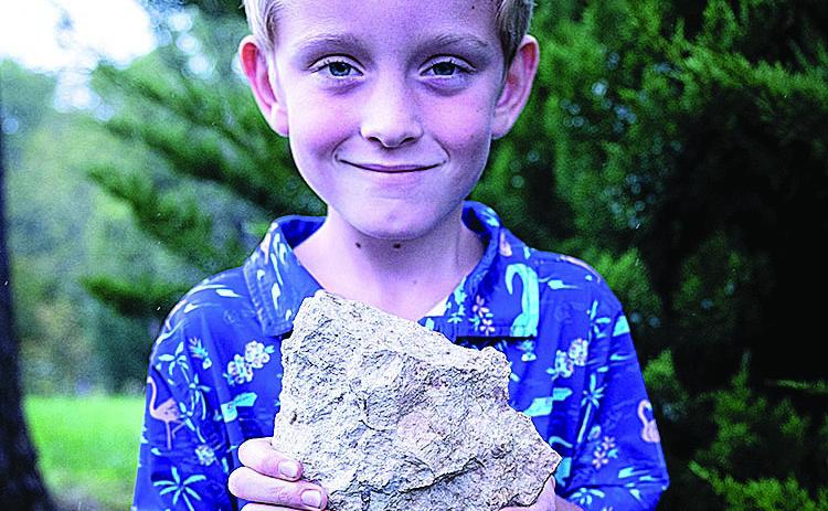 Leo Youngdahl, 6, of Eagle, holds the rare fossil he discovered at Schramm Park near Gretna