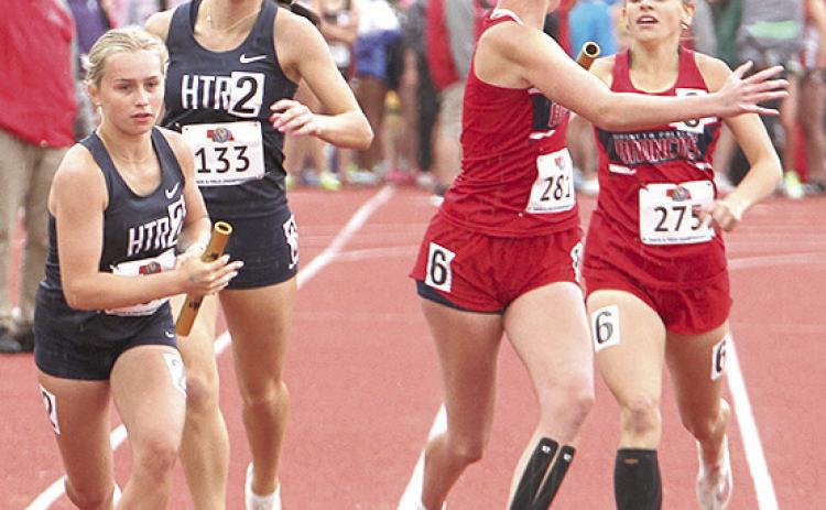 HTRS’ Miranda Rist (left) takes the handoff from teammate Lillian Bowen (#133) in the Class D girls’ 1600 M. Relay on Saturday. Photo courtesy of Stephanie Croston/Seward County Independent