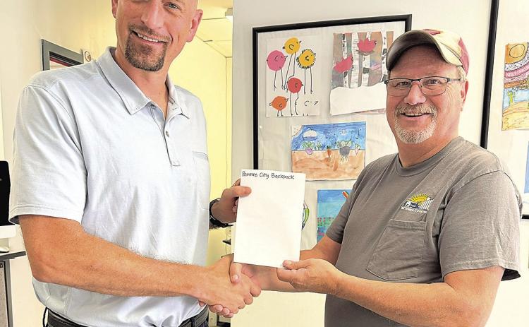 Suberintendent Rottinghaus left accepting donation from Jeff Wehrbein right.