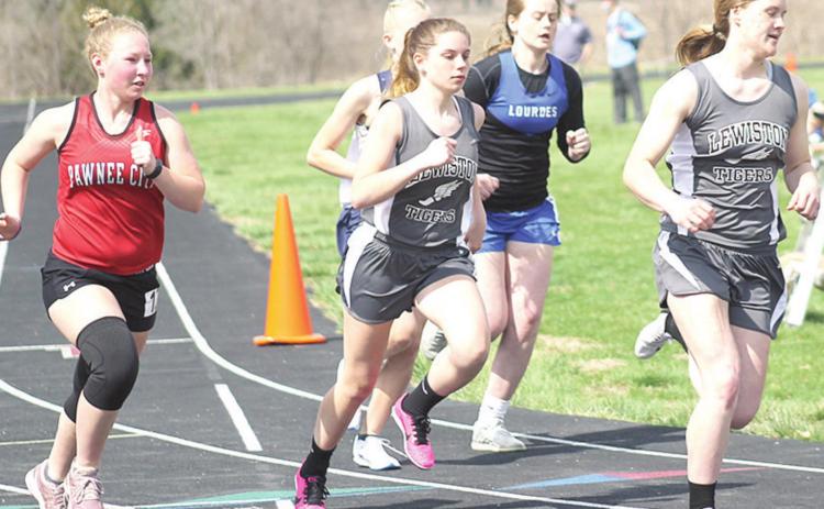 Lewiston’s Emma deKoning (right) leads the pack around the corner as teammate Masyn Arena (center) and P.C.’s Alyssa Pierce (left) follow in stride in the 3200. Paula Jasa/Republican