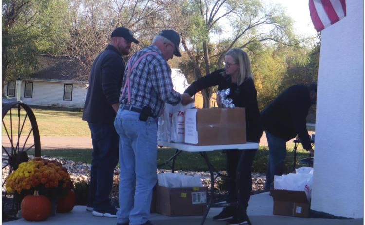 Farmers got a present from First Bank of Nebraska in Burchard Thursday afternoon. They received a meal to go with other goodies as a way of saying thanks for all their efforts during harvest. The event called Harvest Bonanza was co-sponsored by KUTT. Pictured is Ron Leitschuck getting goodies from the bank’s Linda deKoning. Ray Kappel/Republican