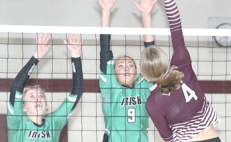 LHS’ Emma deKoning (#4, right) skies for a tip over two FCSH blockers. Paula Jasa/Republican