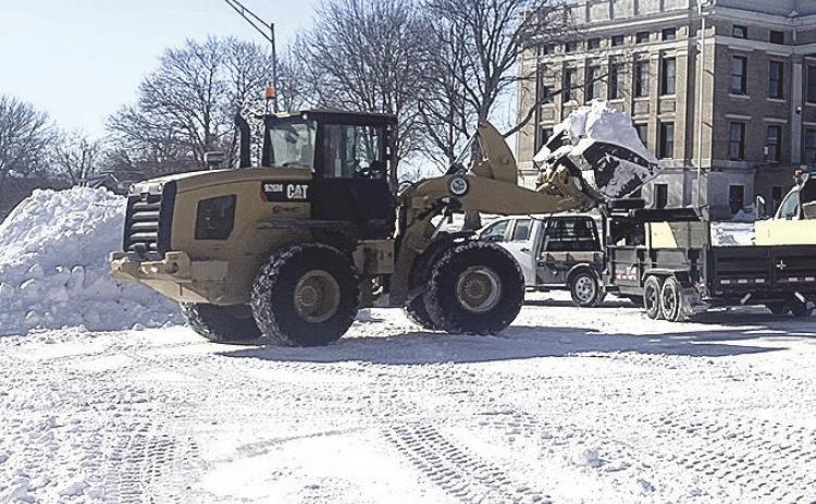 Above: Pawnee City workers cleared snow off the streets on Monday while Below: Ron Puhalla cleared the three foot snow dift in front of the newspaper office just in time for Betty Davis to come to work.