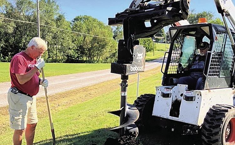 Terry Borcher (L) and Ric Helms (R) use equipment to dig holes for new trees