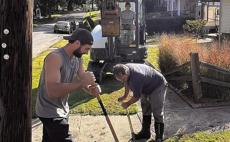 City crew members cautiously dig to uncover natural gas lines before restoring water